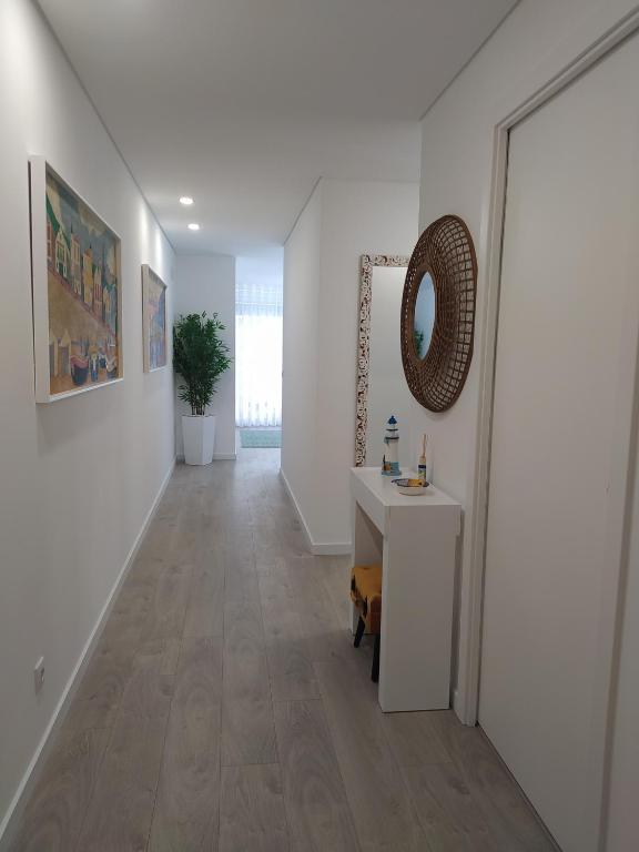 a hallway with a table and a mirror on the wall at Apartamento Estrela do Mar in Nazaré