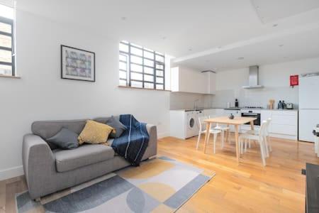 ein Wohnzimmer mit einem Sofa und einem Tisch in der Unterkunft Trendy East London Flat SH11 in London
