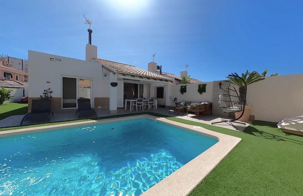 a villa with a swimming pool in front of a house at MAR DE CRISTAL CHALET in Mar de Cristal