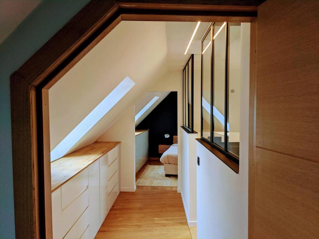 an attic room with a staircase and a bedroom at La Reid, entre 2 vallées in Fraineux