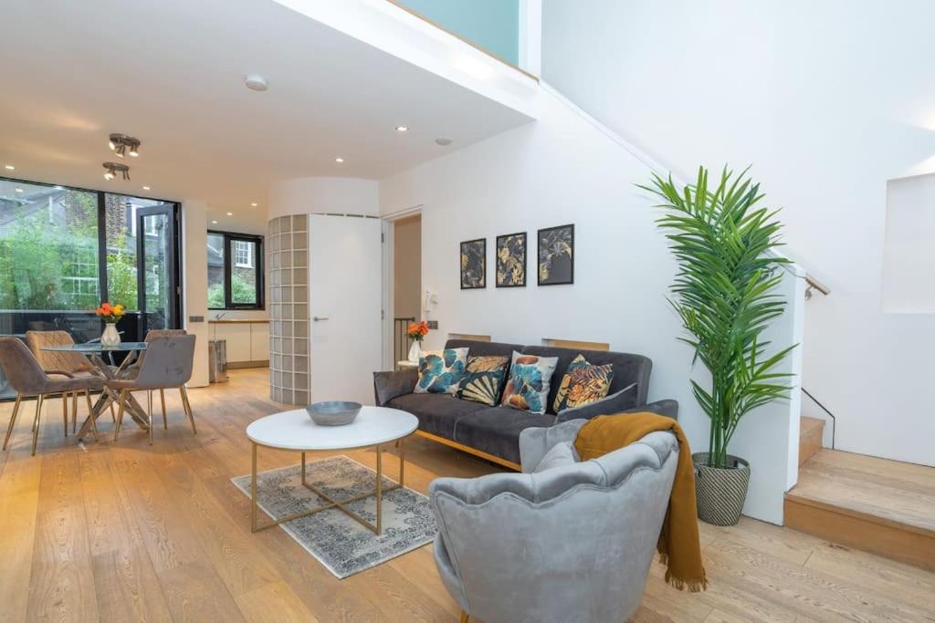 uma sala de estar com um sofá e uma mesa em Award Winning 2 Bedroom House, King's Cross em Londres