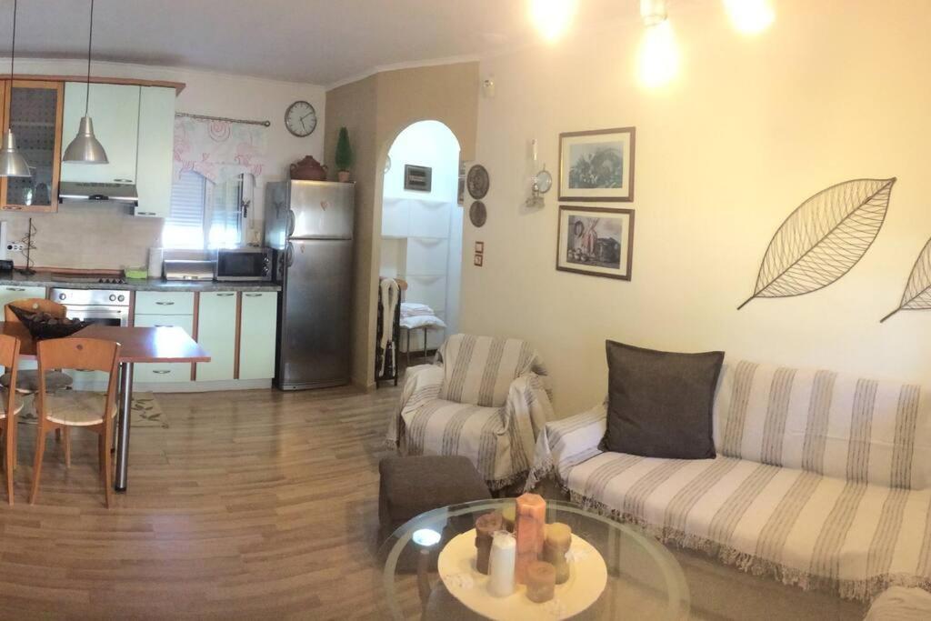 ein Wohnzimmer mit einem Sofa und einem Tisch in der Unterkunft The Little Blooming House in Agíasma