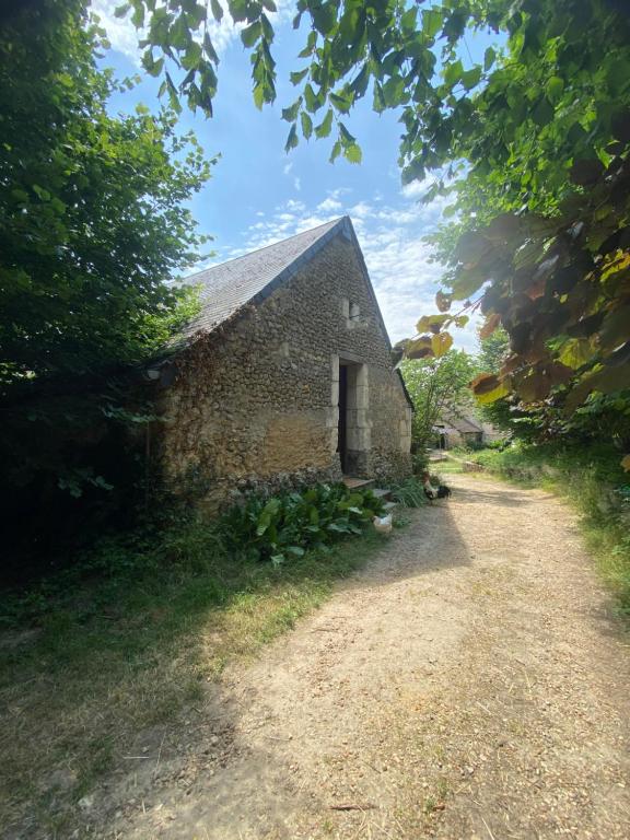 an old stone barn with a dirt road at Loire Valley Llama Farm Stay in Lavernat