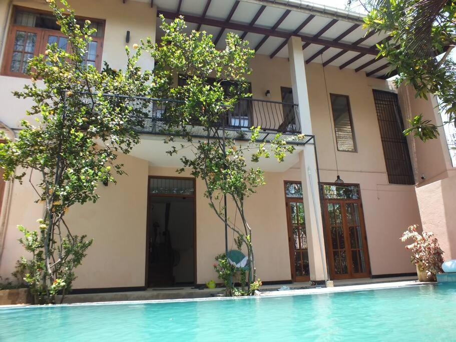 una casa con piscina frente a un edificio en A tropical paradise; stunning house, pool, garden, en Wattala