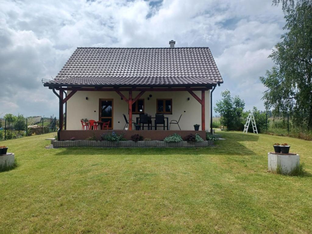 een klein wit huis met een tuinhuisje bij Chalupa Na blátě in Hoješín