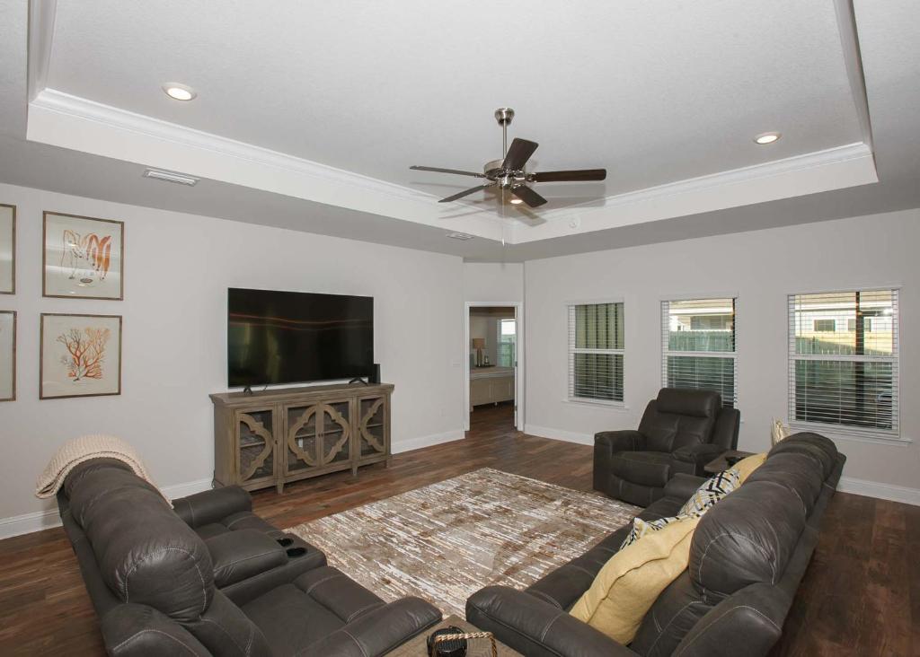 a living room with leather furniture and a flat screen tv at Luxury Getaway House in Foley