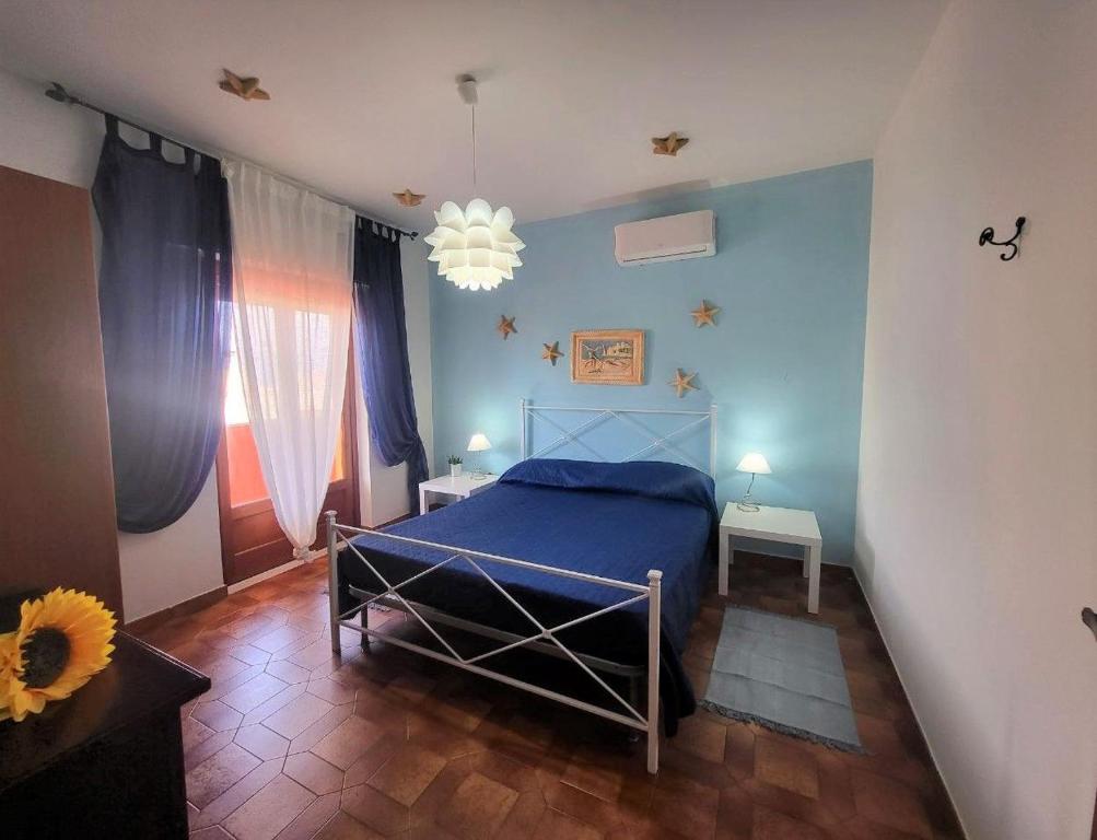 a bedroom with a blue bed and a chandelier at Appartamento Gaia a Tropea in Tropea