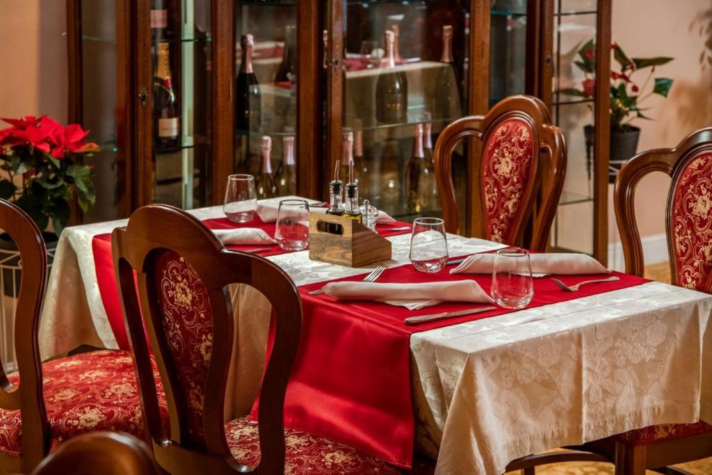 a table with a red table cloth and wine glasses on it at Hotel Cvita in Split