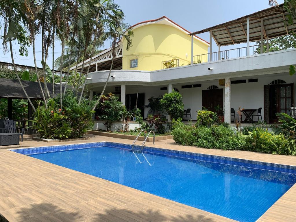 a villa with a swimming pool in front of a house at Ga&iuml;a's Garden B&B Abidjan in Abidjan