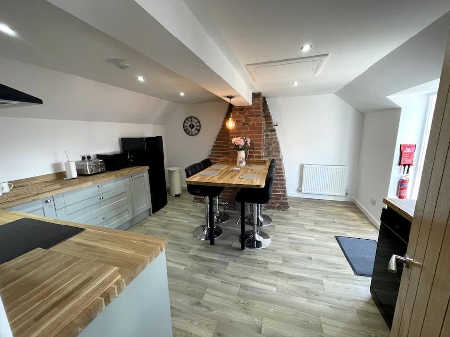 a kitchen with a wooden table in a room at Cosy apartment in Eccleshall in Eccleshall