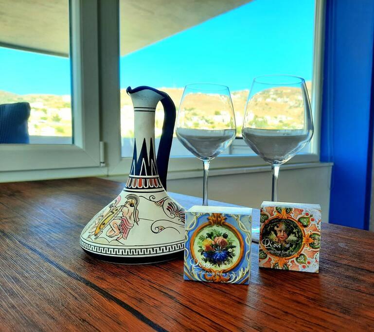 een vaas en twee glazen wijn op een tafel bij Liberty Roof House in Ermoupoli