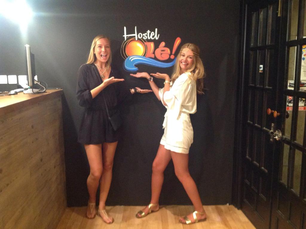 two women standing next to each other in front of a sign at Olé Backpackers Hostel in Alicante