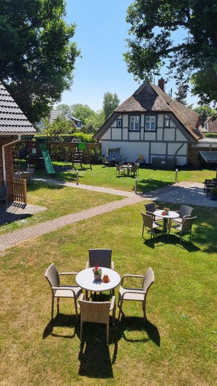 a group of tables and chairs in a yard with a building at Captain Pahlen Ferienanlage in Zingst