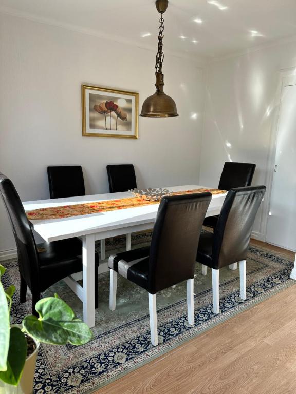 een eetkamer met een witte tafel en stoelen bij Mysiga lägenheter i Kalmar centrum in Kalmar