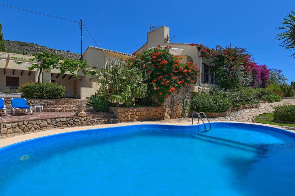 a large blue swimming pool in front of a house at Casa Renata in Jávea