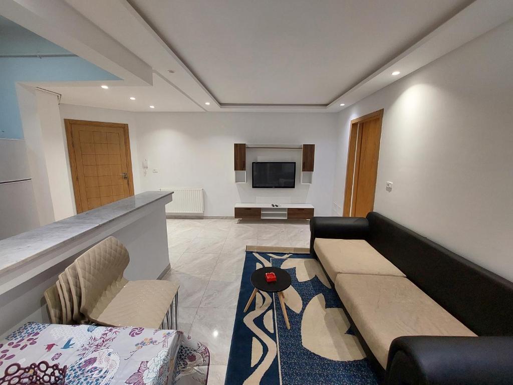 ein Wohnzimmer mit einem Sofa und einem TV in der Unterkunft حي الواحات in Tunis