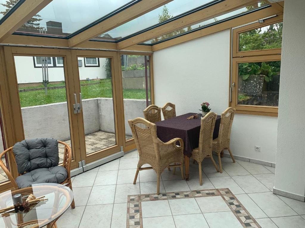 a conservatory with a table and chairs on a patio at Leicht in Münsingen