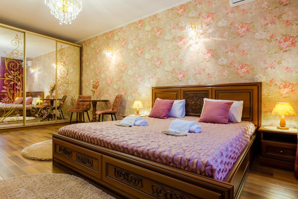 キーウにあるPoznyakoff Aparthotelのピンクの壁のベッドルーム1室(大型ベッド1台付)