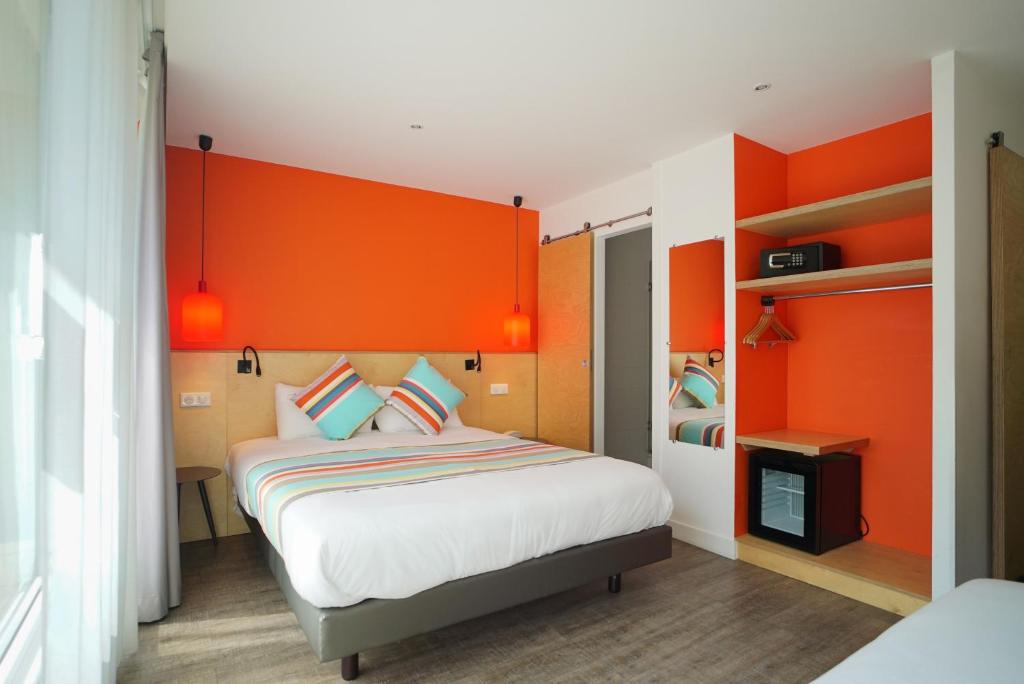 a bedroom with an orange headboard and a bed at La Regence in Courbevoie