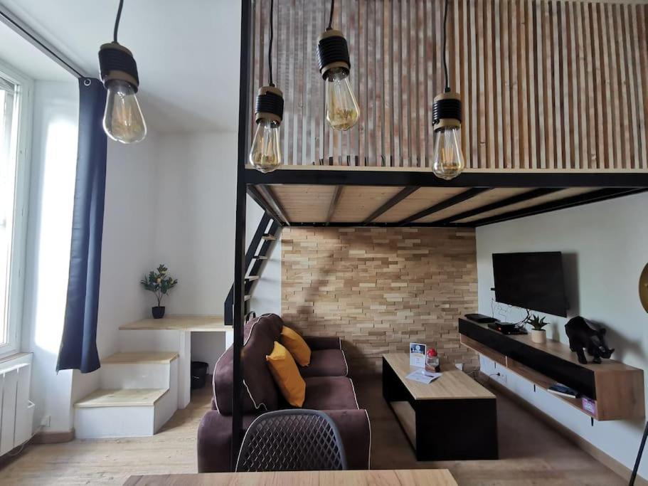 un salon avec un canapé et une télévision dans l'établissement Le Favrel - Appartement avec mezzanine rénové - Gare de Vannes, à Vannes