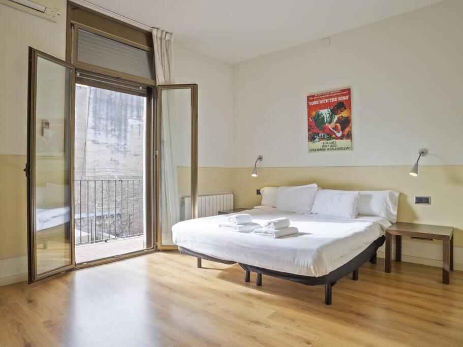 1 dormitorio con cama grande y ventana grande en ¡Apartamento en el centro de Barcelona!, en Barcelona