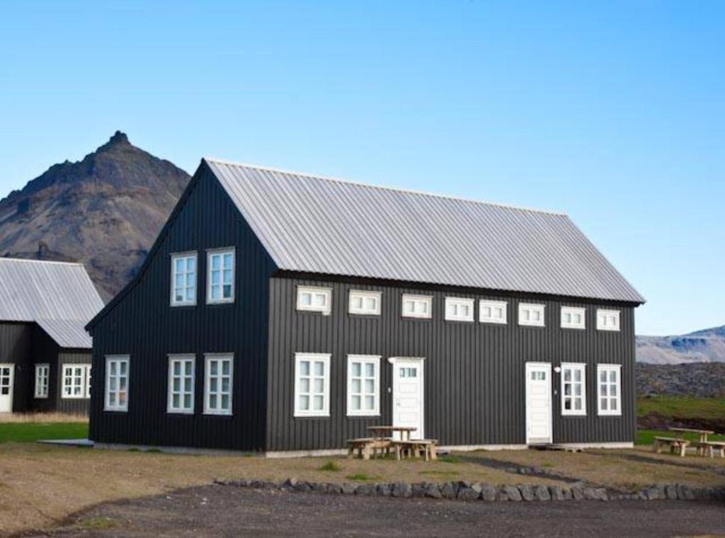 a black and white building with a picnic table at Day Dream Hellnar in Snæfellsbær