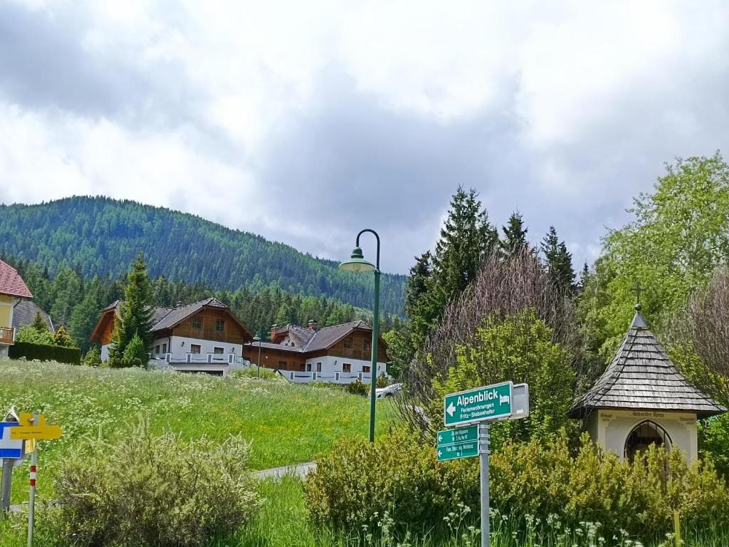 a street sign in front of a village with houses at Ferienhaus Alpenblick in Krakauschatten