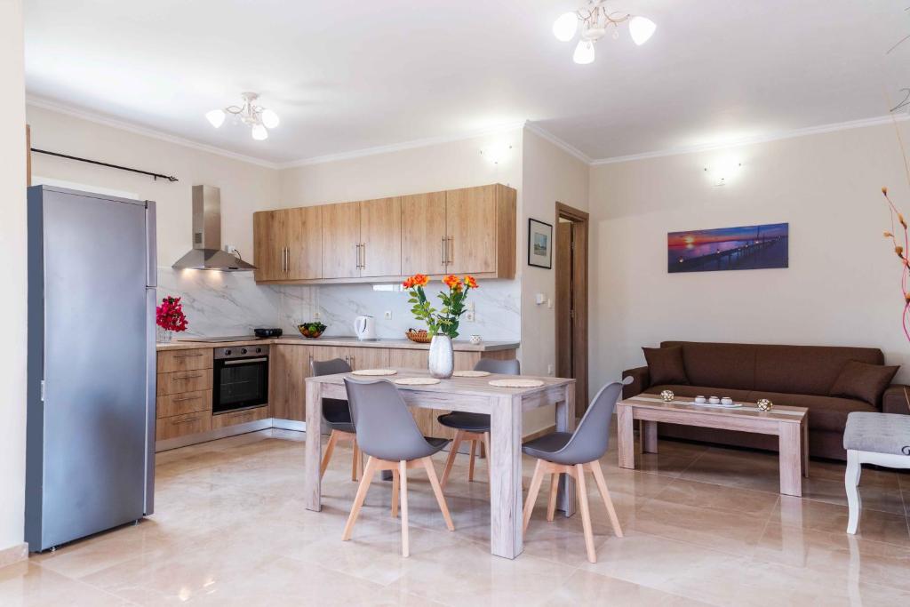 a kitchen and living room with a table and chairs at Villa Georgia in Lefkímmi