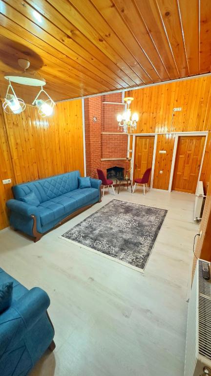 a living room with a blue couch and a table at ZEREN APART 2 CENTRUM in Uzungöl