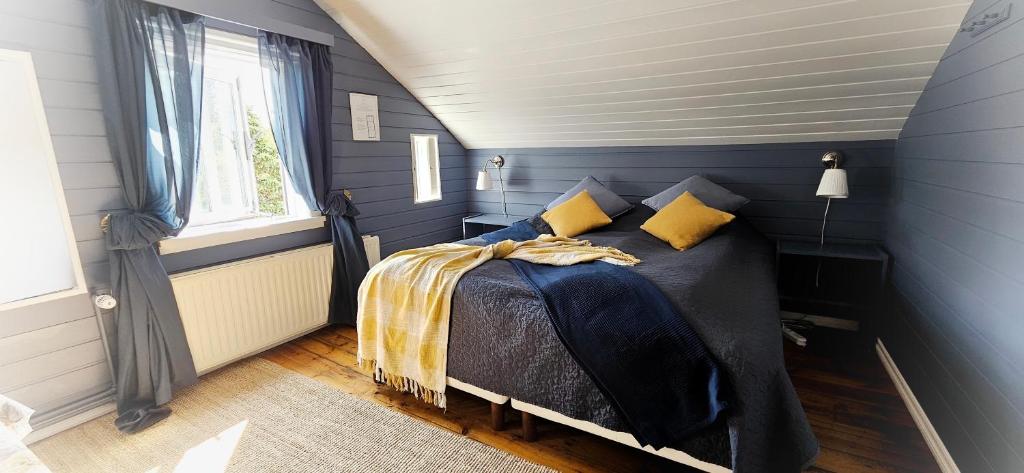 a blue bedroom with a bed with yellow pillows at Árból Guesthouse in Húsavík