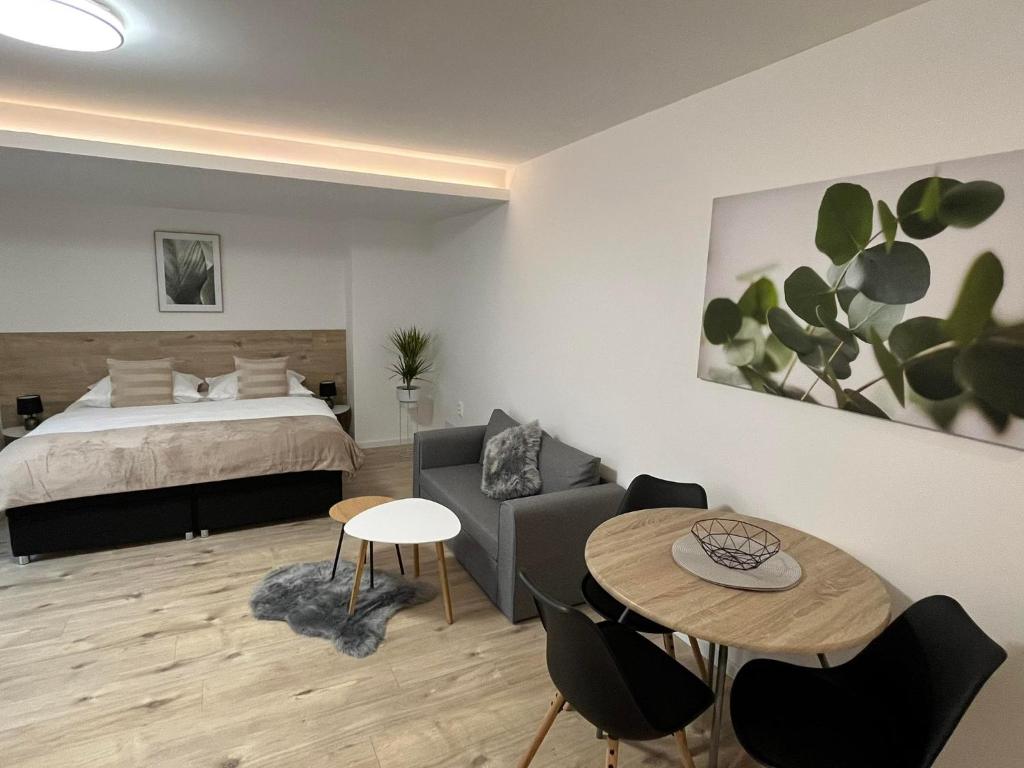 1 dormitorio con cama, mesa y sofá en Ubytovanie MARINEL, en Bojnice