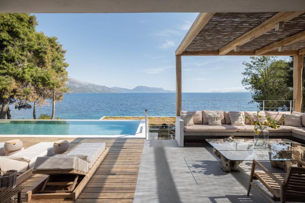 un patio al aire libre con vistas al agua en Villa Mia Terra Stunning Beachfront Villa, en Pogoniá