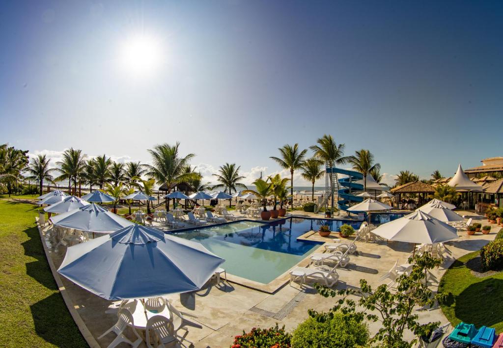 vista aerea su una piscina del resort con ombrelloni di Hotel Praia do Sol a Ilhéus