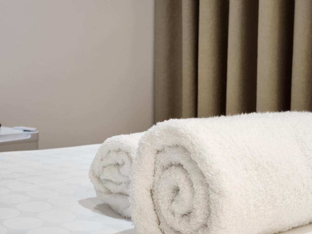 a pile of towels sitting on top of a bed at Sea Front Villa in Vlorë