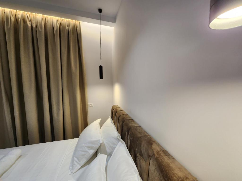 a bedroom with a bed with white sheets and a window at Sea Front Villa in Vlorë