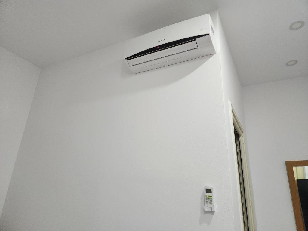 a white air conditioner on a wall in a room at Sea Front Villa in Vlorë