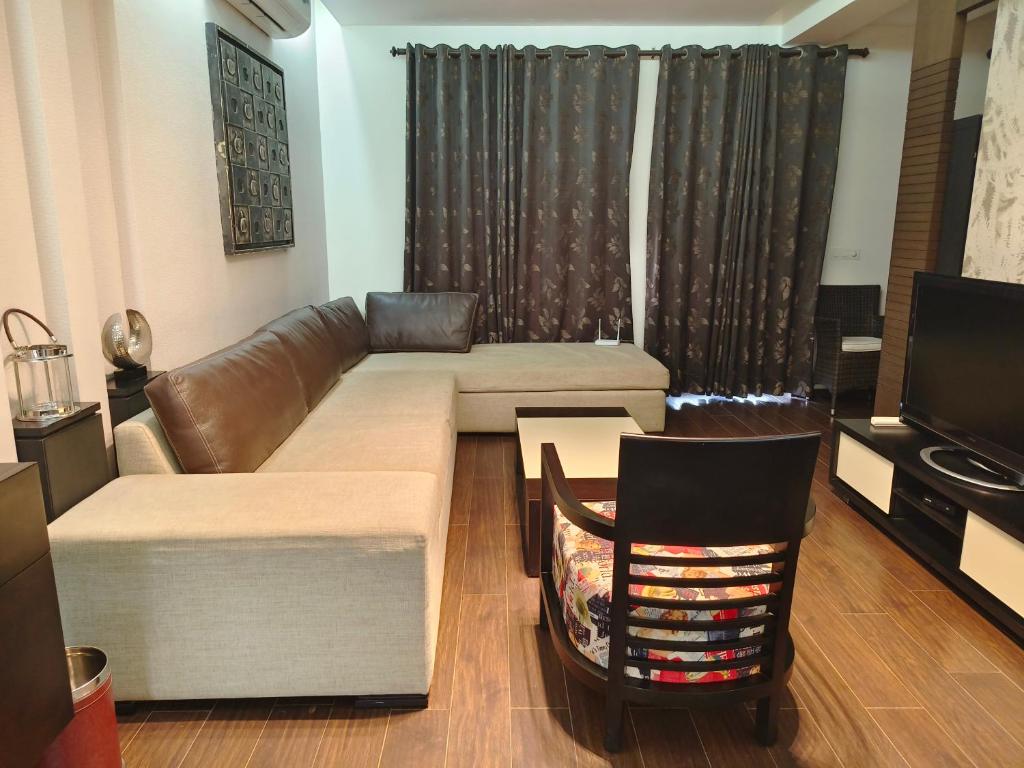 a living room with a couch and a television at BLOSSOM Studio in Manesar