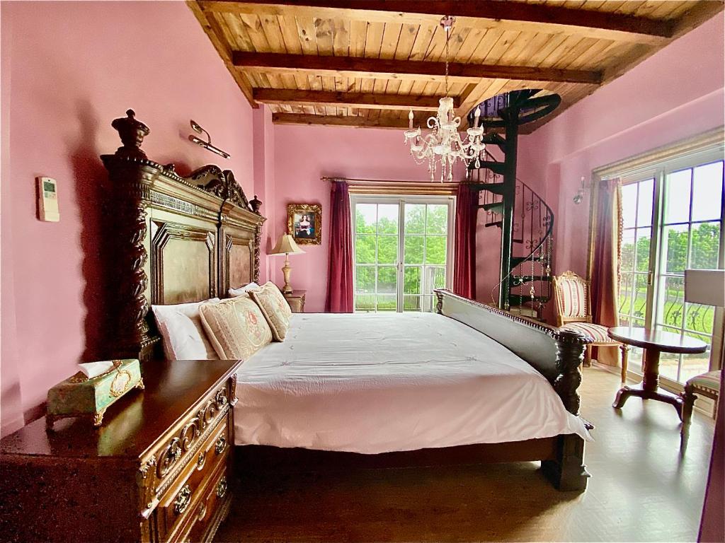 a bedroom with a large bed and a chandelier at England Castle B&amp;B in Wujie