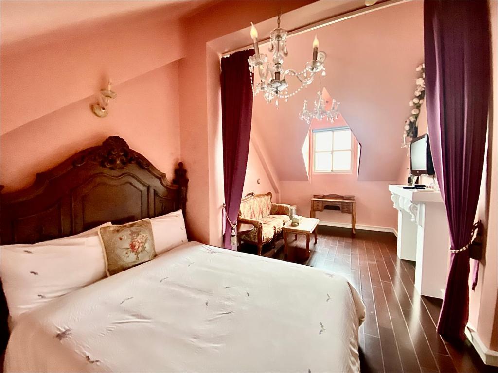 a bedroom with a bed and a chandelier at England Castle B&amp;B in Wujie