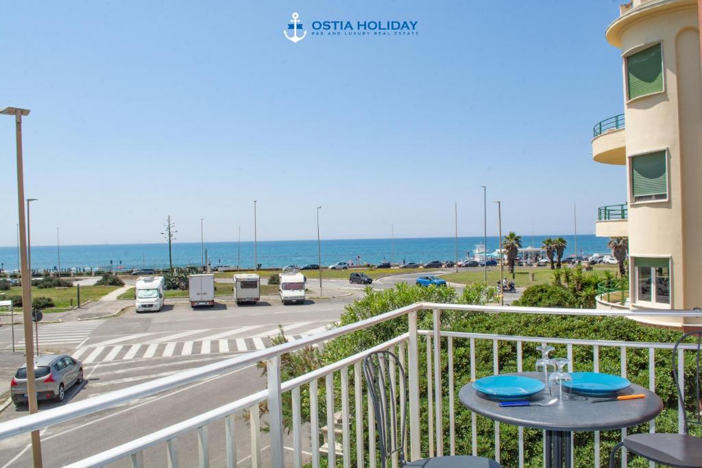 a balcony with a table and a view of the ocean at Ostia Holiday Al Curvone 2 in Lido di Ostia