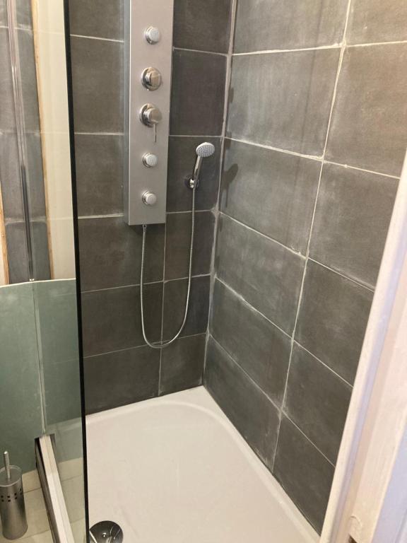 een douche met een glazen deur in de badkamer bij L’Hortense in Oloron-Sainte-Marie