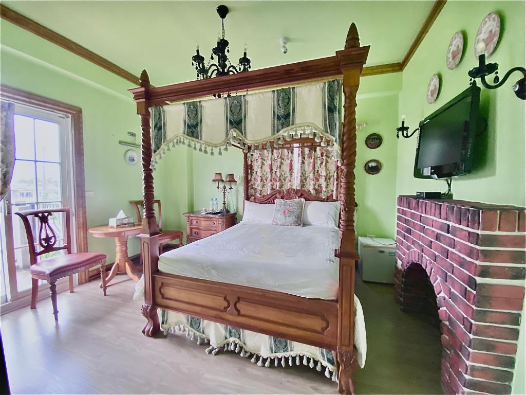 a bedroom with a canopy bed and a fireplace at England Castle B&amp;B in Wujie
