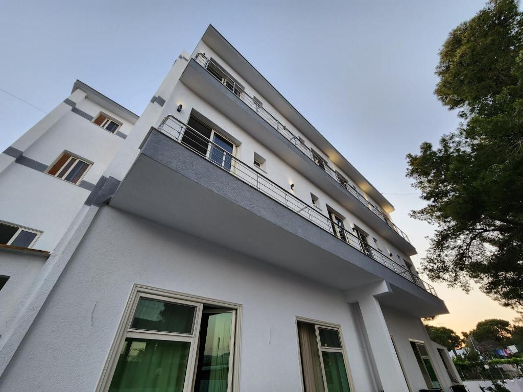 a white building with a balcony on top of it at Sea Front Villa in Vlorë