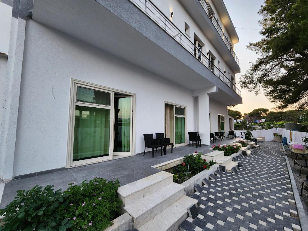 a building with a patio with benches and plants at Sea Front Villa in Vlorë