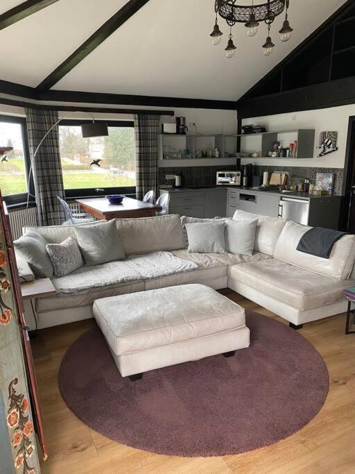 a living room with white couches and a rug at Ferienwohnung Thalia in Berg am Starnberger See