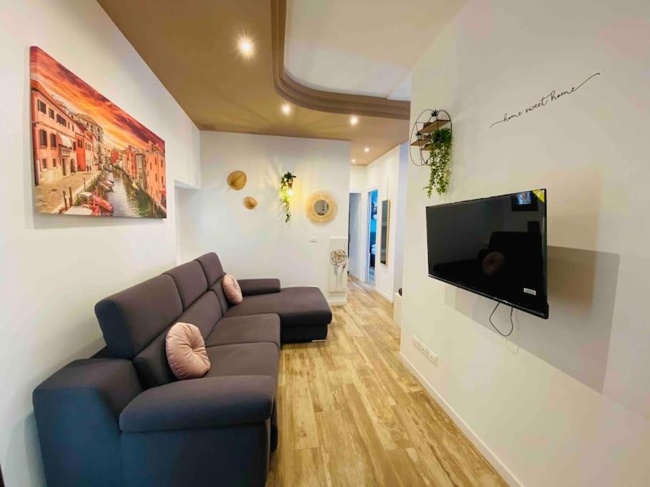 un salon avec un canapé et une télévision à écran plat dans l'établissement Ca' Donin - Centro storico, à Chioggia