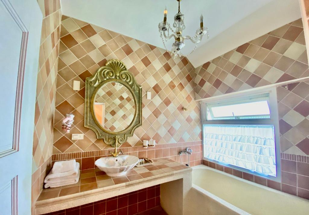 a bathroom with a sink and a mirror and a tub at England Castle B&amp;B in Wujie