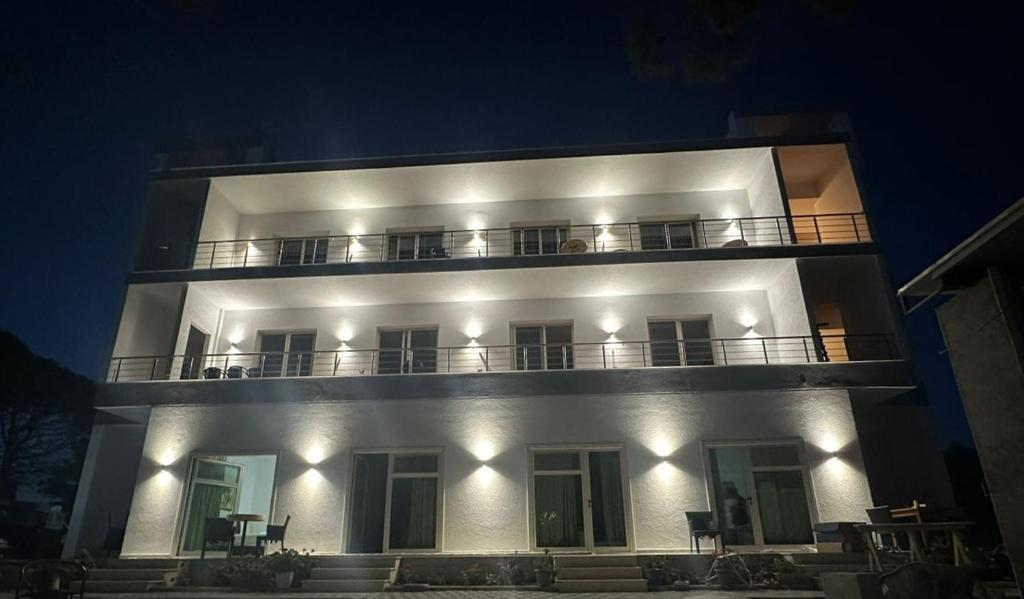 a large white building with a balcony at night at Sea Front Villa in Vlorë