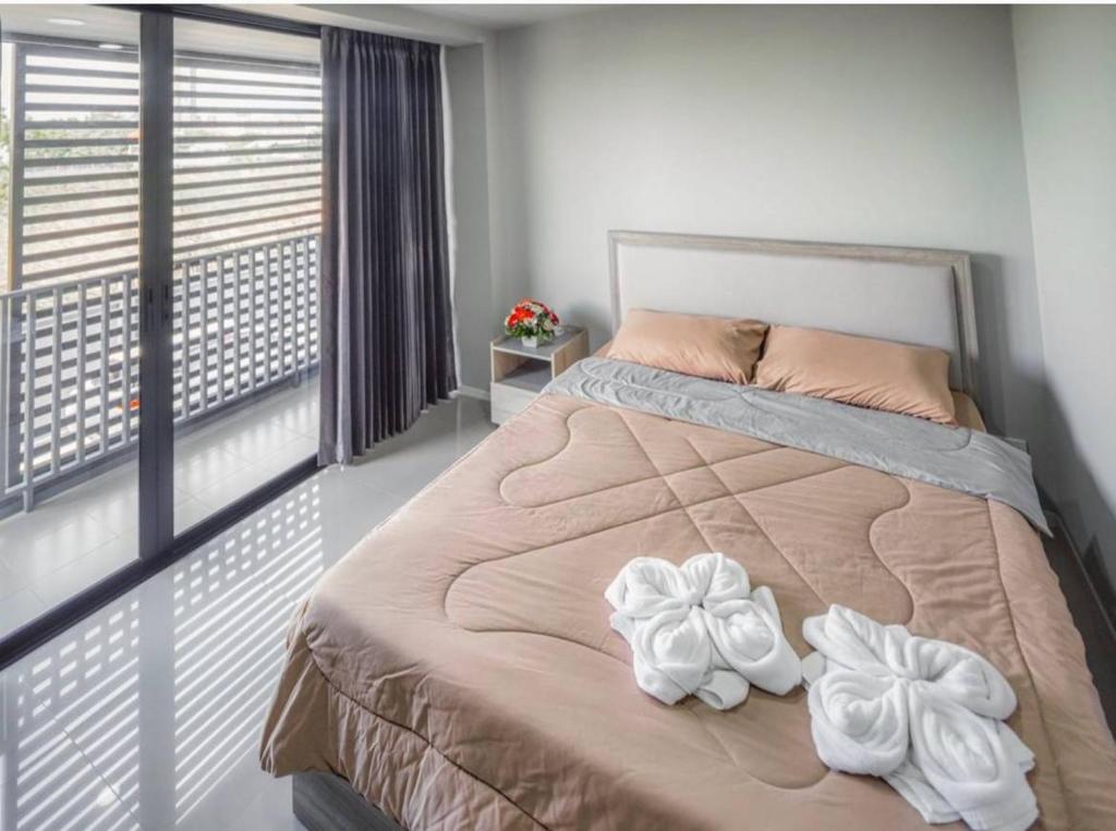 1 dormitorio con 1 cama con 2 toallas en PT Residence Bearing, en Bangna