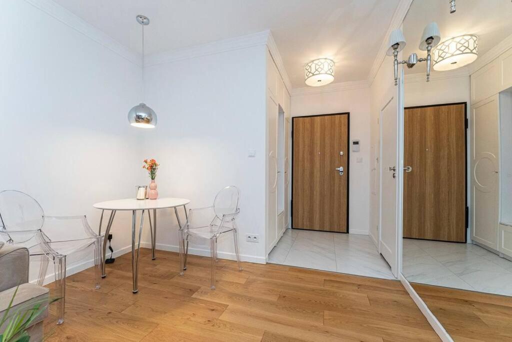 ein Wohnzimmer mit einem Tisch und Stühlen in der Unterkunft Apartment close to Medicover and Paley in Warschau